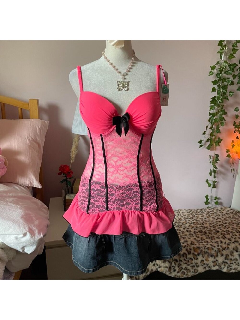 Pink lace corset top with black trim and bow detail